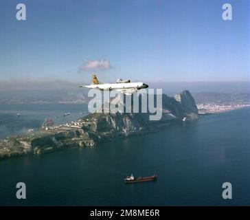 Aerial starboard view of a Patrol Squadron Forty-four (VP-44) P-3C Orion Anti-Submarine Warfare (ASW) aircraft in flight to right. The P-3Cs in flight to Naval Air Station (NAS) Keflavik (Iceland) from NAS Brunswick, Maine. A Super Tanker underway and the Mediterranean side of the Island of Gibraltar is visible in the background. Country: Unknown Stock Photo