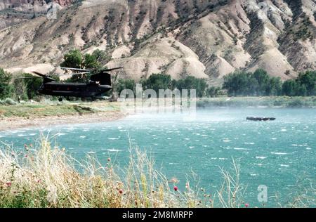 A CH-47 from Detachment 1, Company G, 140th Aviation, Nevada Army National Guard drops off a Zodiac boat for the Naval Explosive Ordnance Disposal Mobile Unit 7 from San Diego, California. Mobile Unit 7 members will search the lake for the four 500 pound bombs carried by the A-10 that crashed on nearby Gold Dust Peak. Base: Big Spruce Lake State: Colorado (CO) Country: United States Of America (USA) Stock Photo