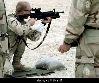 A US Navy SEAL, from SEAL team 8, shoots a Colt 5.56MM M4 Carbine, with a M203 Grenade Launcher attached, on a firing range in Kuwait as part of the Southwest Asia buildup. Country: Kuwait (KWT) Stock Photo