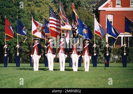 Flag bearers of the 'Old Guard' from the U.S. Army's 3rd Infantry Regiment stand at attention on Summerall Parade Field at Fort Myers, Virginia. The Continental Color Guard (CCG) is the nation's foremost color guard conducting ceremonies, memorial affairs and special events to demonstrate the excellence of the United States Army to the world. The soldiers in the foreground wear traditional Revolutionary War uniforms and carry the flags (pictured from left to right) of the United States of America, United States Army and the 3rd Infantry Division. Soldiers in the background wear the current Dre Stock Photo