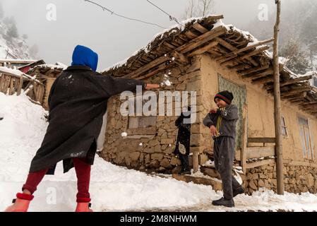 Srinagar, India. 15th Jan, 2023. Kid play with snow outside their mud house after a heavy snowfall in the outskirts of Srinagar. Due to heavy snowfall, there has been multiple avalanche in different places of Kashmir. The period of 40 days from December 21 to January 31st, also known as Chilai Kalan, in Kashmir is considered as the most crucial when if it snows the condition gets even worse. Credit: SOPA Images Limited/Alamy Live News Stock Photo