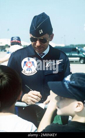 During an air show, US Air Force Captain Charlie Underhill, Executive Officer, of the Air Force Thunderbirds signs autographs for the special needs children on the Tyndall Air Force Base flightline. Base: Tyndall Air Force Base State: Florida (FL) Country: United States Of America (USA) Stock Photo