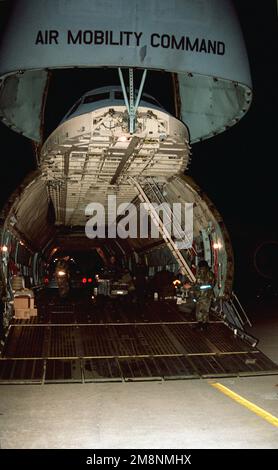 Personnel from the 23rd Fighter Group (FG) and the 3rd Aerial Port Squadron at Pope Air Force Base, North Carolina, along with crew members from the 436th Airlift Wing at Dover Air Force Base, Delaware, prepare to load an MJ-1 bomb loader onto a C-5B on the Green Ramp in the early morning hours. The loader along with numerous other pieces of support equipment and 60 23rd Fighter Group personnel, deployed to the Kosovo area of operations to maintain and support four A-10A Warthog Thunderbolt II ground attack aircraft of the 23rd FG that departed Pope AFB the previous morning. Base: Pope Air For Stock Photo