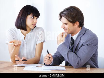 Collaboration in the office. Two young executives going over a project budget together. Stock Photo
