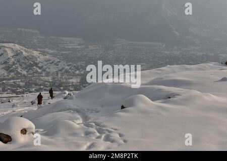 Srinagar, India. 14th Jan, 2023. Visitors walk through a snow covered hill after a fresh snowfall on the outskirts of Srinagar. Weather improved in Kashmir valley after days of moderate to heavy snowfall and rains. Meanwhile, Avalanches were reported on Saturday in Bandipora district and Sonamarg hill station which have been witnessing moderate to heavy snowfall over past few days. This is the second incident reported in the popular hill station in the last two days. Two labourers died on Thursday when an avalanche hit the work site of a construction company in Sonamarg. Credit: SOPA Images Li Stock Photo