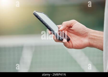 Closeup of unknown mixed race tennis player using cellphone during break in game on court. Hispanic fit athlete browsing internet and networking on Stock Photo