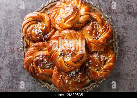 Homemade tasty Kanelbulle the nordic cinnamon rolls close-up on a plate on the table. Horizontal top view from above Stock Photo