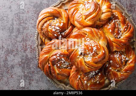 Kanelbullar or Kanelbulle is a traditional Swedish cinnamon buns flavored with cinnamon and cardamom spices and topped with pearl sugar close-up on a Stock Photo