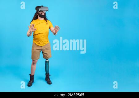 Man with prosthetic leg gesturing while using a virtual goggles Stock Photo