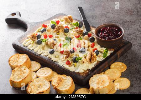 Sweet Butter board with dried cherries and figs, pistachios, hazelnuts, fresh blueberries and mint close-up on the table. Horizontal Stock Photo