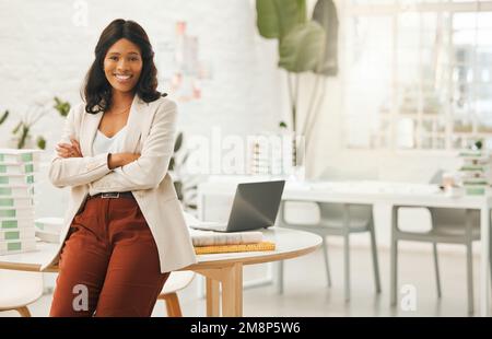 African american businesswoman sitting on her desk. Portrait of a businesswoman with her arms crossed. Young designer in her agency. Creative Stock Photo