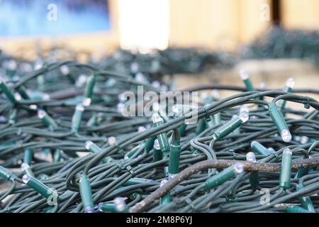 Light chains consisting of small bulbs connected with green cables. Stock Photo