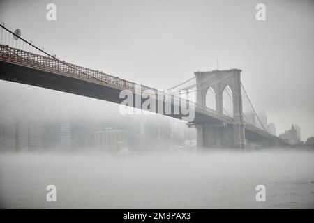 New York city Brooklyn Dumbo area with landmark Brooklyn Bridge in the mist hiding the iconic skyline Stock Photo