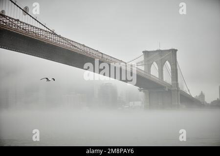 New York city Brooklyn Dumbo area with landmark Brooklyn Bridge in the mist hiding the iconic skyline Stock Photo