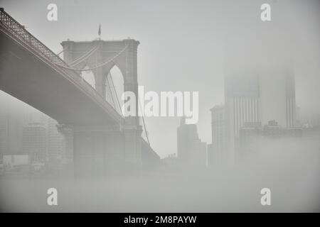 New York city Brooklyn Dumbo area with landmark Brooklyn Bridge in the mist hiding the iconic skyline Stock Photo