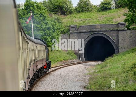 A steam train approaching the Greet tunnel situated south of Winchcombe station in the Cotswolds in Britain.  The Greet Tunnel is the second lo Stock Photo