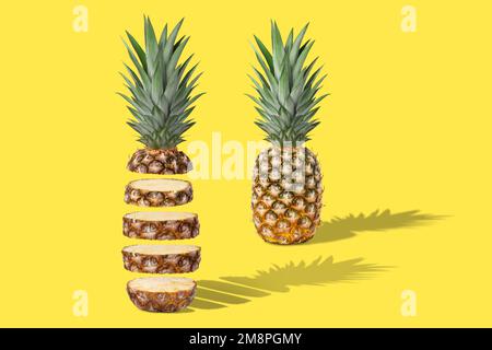 Two fresh juicy pineapples, whole and sliced. Concept. On a yellow background. Stock Photo