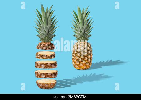 Two fresh juicy pineapples, whole and sliced. Concept. On a blue background. Stock Photo