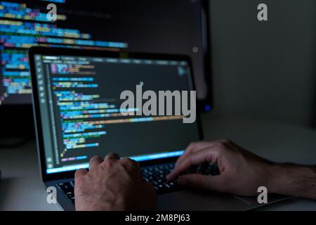 Male hands writing code on laptop. Software and web development with javascript and html Stock Photo