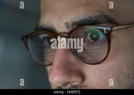 Line of code reflected in glasses of software programmer and web developer Stock Photo