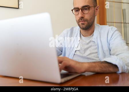 Young male with glasses using laptop Stock Photo