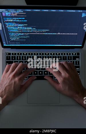 Vertical shot of hands writing code on laptop. Software and web development Stock Photo