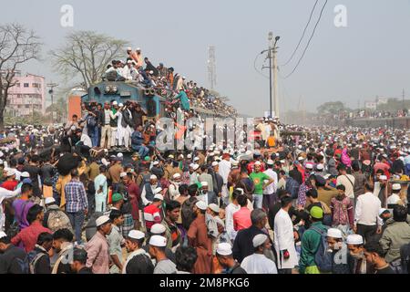 Dhaka, Dhaka, Bangladesh. 15th Jan, 2023. Muslim devotees travel by overcrowded risky trains after attending the Akheri Munajat or final prayers, at the Biswa Ijtema in Tongi, Dhaka, Bangladesh.Locals tackle the journey climbing on, clinging to and clambering along the roofs of locomotives. With no seats available inside, many commuters decide to take the risk and choose a rooftop view for their journey out of Dhaka city.Million of Muslim devotees from around the world join the four-day long event that culminates in the Akheri Munajat or the Concluding Supplication (Final Prayer) in which mu Stock Photo