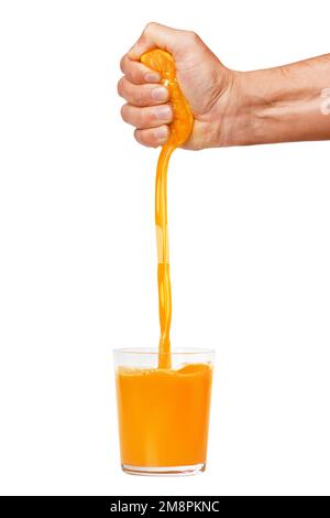 A man's hand squeezes a ripe orange into a glass. A man is holding and squeezing an orange. Orange juice is pouring. Isolated on a white background. Stock Photo