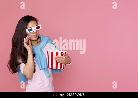 woman watching movie film, holding bucket of popcorn Stock Photo