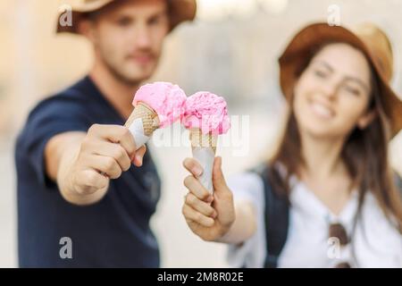 Happy couple eating ice cream in Rome, Italy. Beautiful bright ice cream with different flavors in the hands of a couple Stock Photo