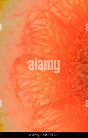Grapefruit close-up. Slice of blood red ripe grapefruit. Texture of red juicy grapefruit. Macro vertical image. Stock Photo