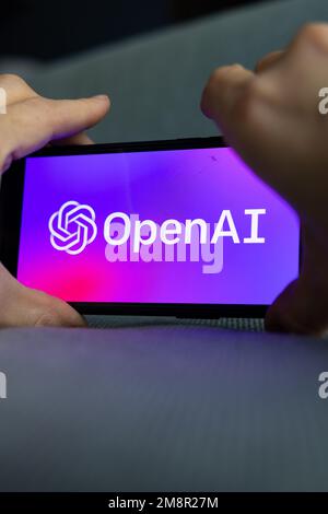 Woman's hand holding an iPhone with OpenAI logo. ChatGPT and Chat bot culture, artificial intelligence time. 01.01.2023 Amsterdam, Netherlands Stock Photo