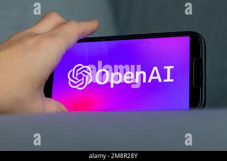 Woman's hand holding an iPhone with OpenAI logo. ChatGPT and Chat bot culture, artificial intelligence time. 01.01.2023 Amsterdam, Netherlands Stock Photo