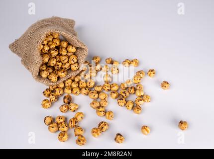 Spilling Roasted Chickpeas In Sack Isolated On White Background. Stock Photo