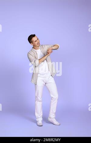 man in casual shirt posing on purple background. Stock Photo