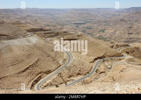 Jordan - winding desert road of the Kings Highway descending into Wadi Mujib Canyon Stock Photo