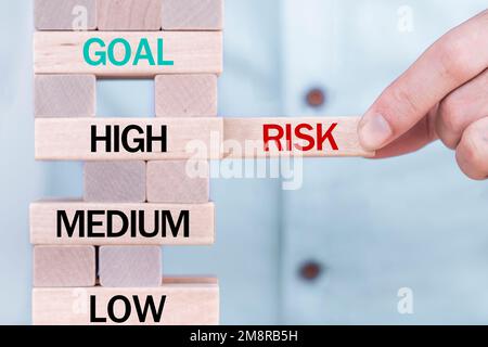 Hand holding chooses wooden block cubes with risk word. Risk management concept. Stock Photo