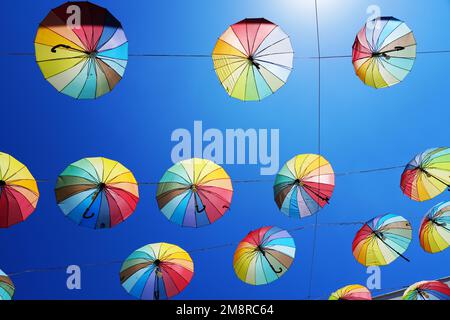 Colorful umbrellas for sun protection. Blue sky in the background. Rainbow colors. Stock Photo