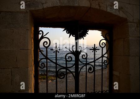 Traditional handcrafted wrought iron main entrance gate of Aghioi Theodoroi a picturesque Greek Orthodox church in Plakakia beach Aegina island Greece Stock Photo
