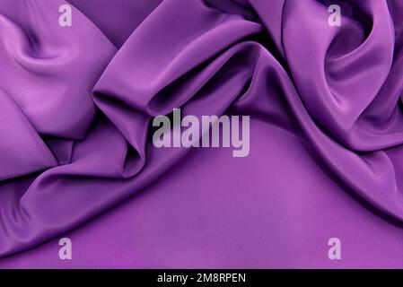 A piece of burgundy, violet, red cloth. Fabric texture for background and design works of art, beautiful wrinkled pattern of silk or linen. A crumpled Stock Photo