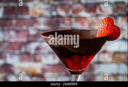 Chocolate dipped Valentine's Day cocktail with a heart shaped strawberry garnish Stock Photo