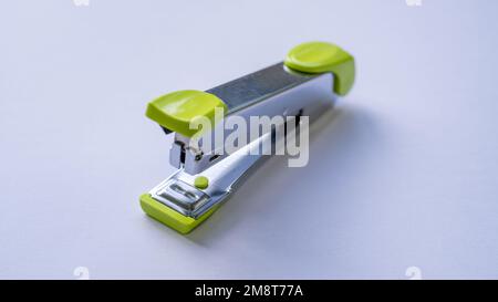Green stapler on a white background Stock Photo