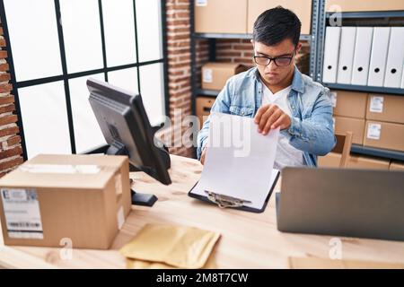 Down syndrome man ecommerce business worker reading document at office Stock Photo