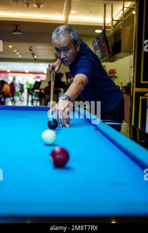 Old man with serious style playing billiards Stock Photo