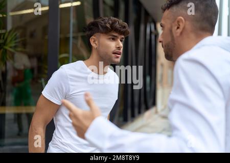 Two hispanic men couple arguing at street Stock Photo