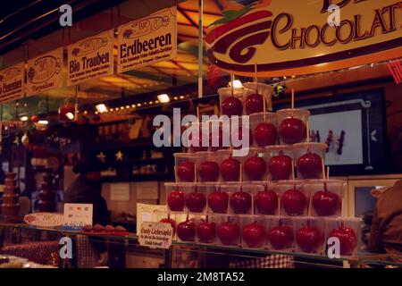 Red toffee apples on sale in winter market stalls, Germany, Winter 2022 Stock Photo
