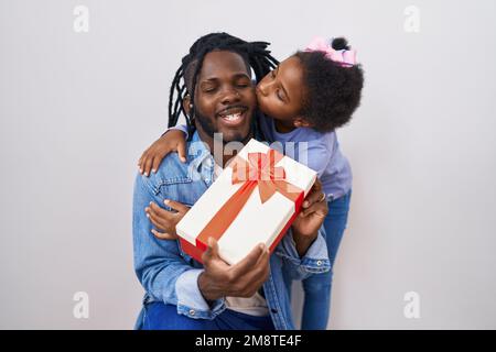 Father and daughter surprise with gift hugging each other over isolated white background Stock Photo