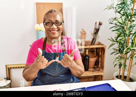 Senior african american woman communicating with deaf language at art studio Stock Photo