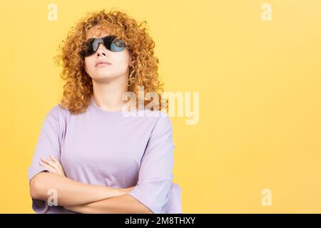 Rude woman with sunglasses standing with arms crossed Stock Photo