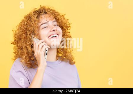 Woman talking to the mobile while smiling with eyes closed Stock Photo